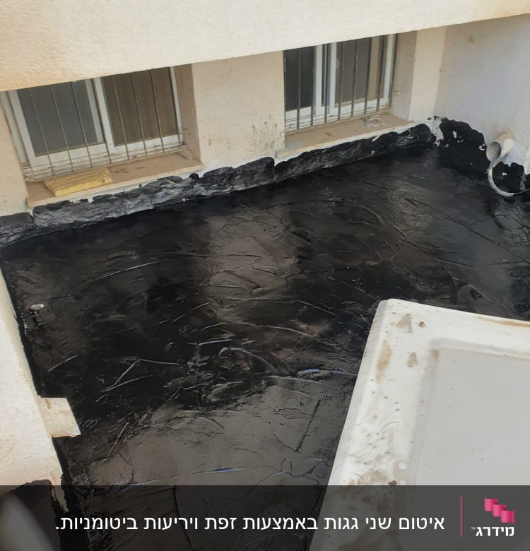 איטום גג עם חומר שחור ליד חלונות